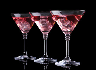 Red cocktail in martini glasses isolated on black