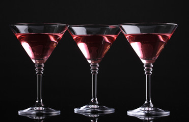 Red cocktail in martini glasses isolated on black