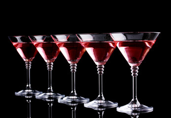 Red cocktail in martini glasses isolated on black