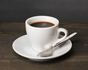 Obraz premium Coffee cup on wooden table on grey background