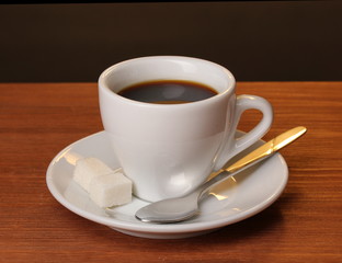 Coffee cup on wooden table on brown background
