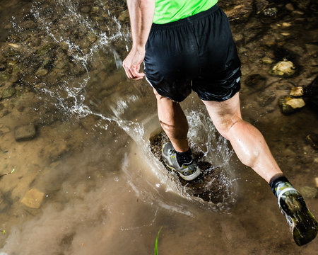 Jogger durchquert einen Bach