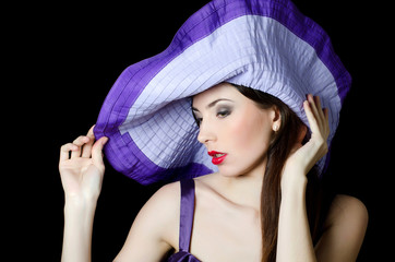 Portrait of the beautiful elegant woman in a lilac hat
