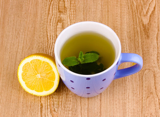 Mint tea with mint leaf and lemon on wooden background