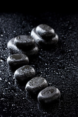 Spa stones with drops on black background