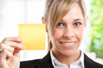 Beautiful businesswoman showing a blank post-it