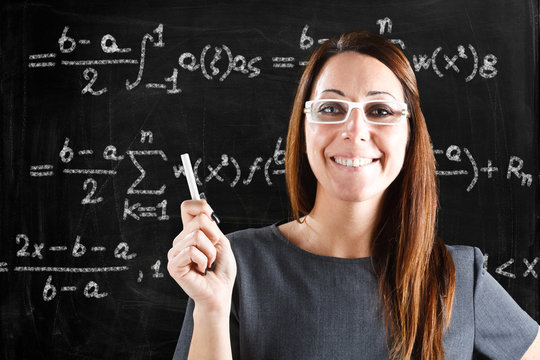 Teacher showing a math formula on a blackboard