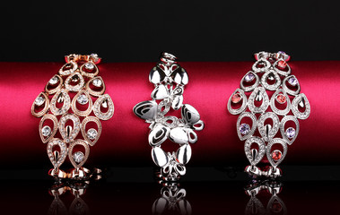 Three elegant bracelets on the pink cloth on black background