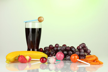 The composition of the lollipops, fruit and a glass of cola