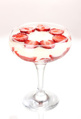 Glass of ripe strawberries with cream isolated on white