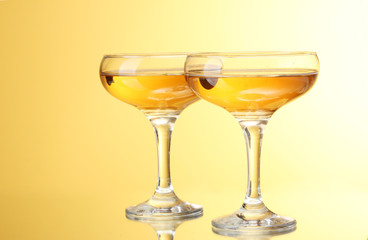 glasses of champagne on yellow background