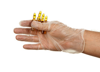 Hand holding ampules with yellow drug