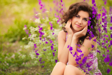 Beautiful young woman in purple flowers outdoors