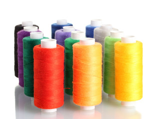 Many-coloured bobbins of thread isolated on white
