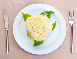 Fresh cauliflower on plate, knife and fork