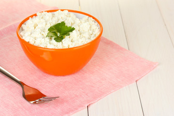 cottage cheese with parsley in orange bowl and fork