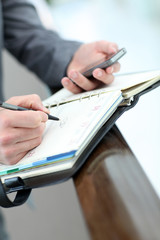 Closeup of businessman hand writing on agenda