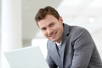 Businessman using laptop computer in entrance hall