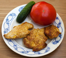 three pieces of roasted meat with tomato and cucumber