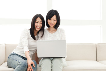 Fototapeta premium Beautiful young women using a laptop computer. Portrait of asian