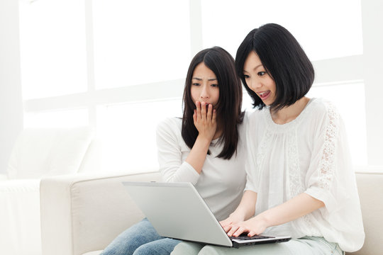 Beautiful young women using a laptop computer. Portrait of asian