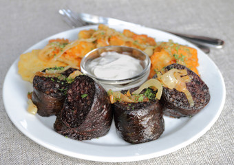 Homemade blood sausage with potato pancakes and sour cream