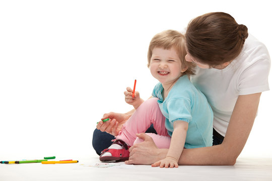 Happy laughing child drawing with her mother