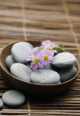 Fototapeta na wymiar bowl of flower with stones in bowl on bamboo mat