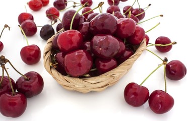 cherries spilling out from the basket on white background