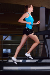 Fototapeta na wymiar beautiful woman is running on the treadmill