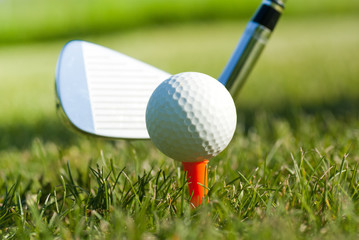 golf ball on tee and club behind