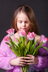 beautiful  little girl with bouquet of pink tulips