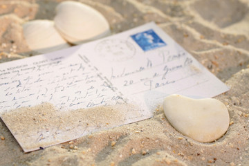 Herz und Postkarte im Sand