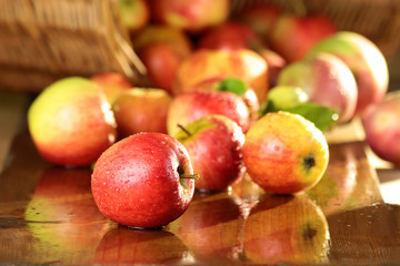 Korb mit Äpfeln auf nassem Tisch