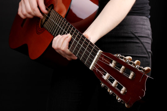 Guitar in hands isolated on black