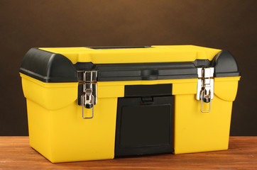 yellow tool box on brown background close-up