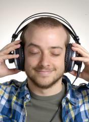 joven dj sujetando audífonos,escuchando música.