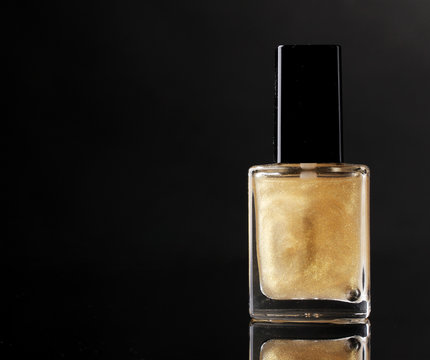 Golden nail polish on black background