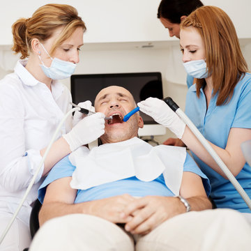 team beim zahnarzt behandelt einen patienten