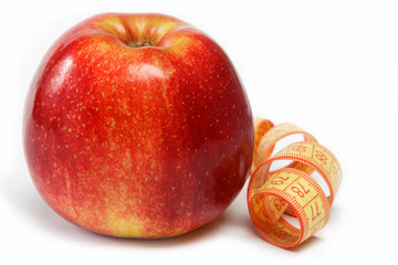 Red apple and measuring tape on a white background.