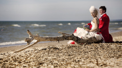Bride and groom sitting by the sea