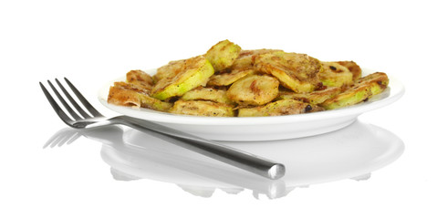 Fried zucchini in a white plate with fork isolated