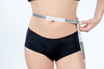 femme mesurant son ventre plat en boxer noir