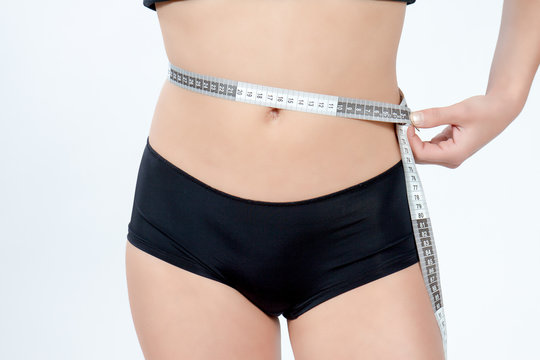 femme mesurant son ventre plat en boxer noir