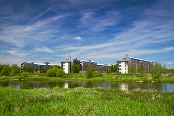 Fototapeta na wymiar Apartments at the river in summer scenery