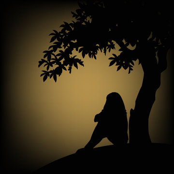 The outline of a girl sitting near a tree