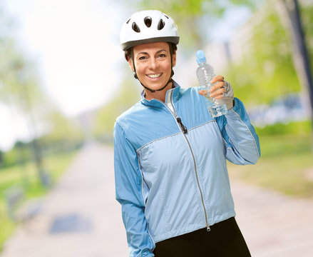 portrait of cyclist middle aged woman holding a water bottle at