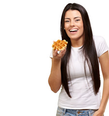 portrait of young woman holding waffle over white background