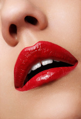 Fototapeta premium Close-up shot of woman lips with glossy red lipstick