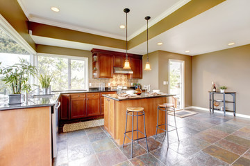 Luxury kitchen interior with green walls and stone floor.